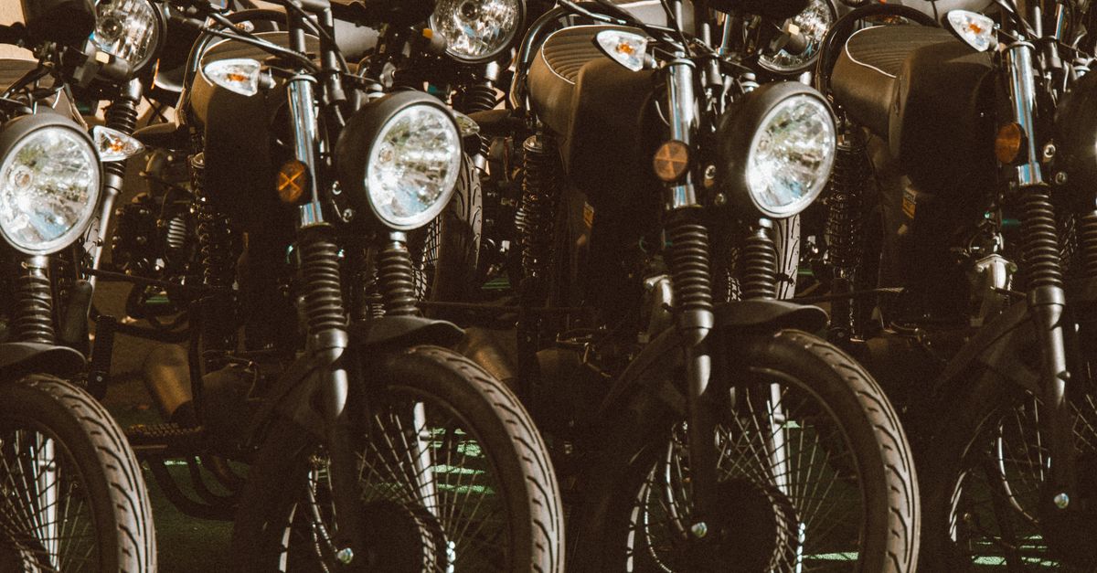 A stylish lineup of vintage motorcycles parked in a sunlit outdoor setting.